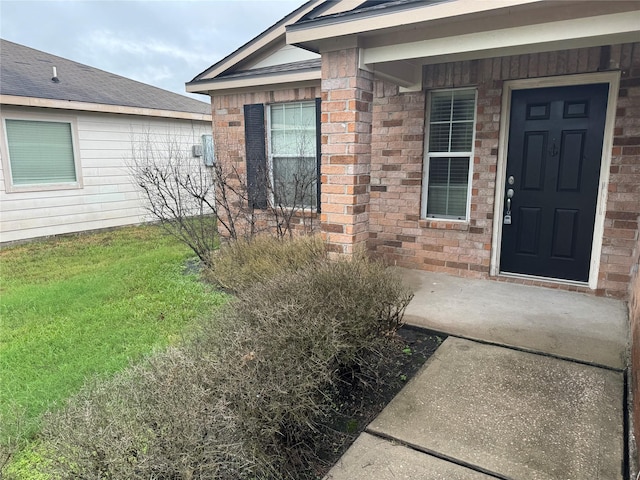 property entrance featuring a lawn