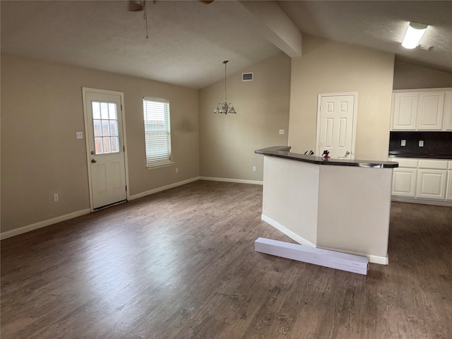 kitchen featuring decorative light fixtures, lofted ceiling with beams, white cabinets, backsplash, and dark wood-type flooring