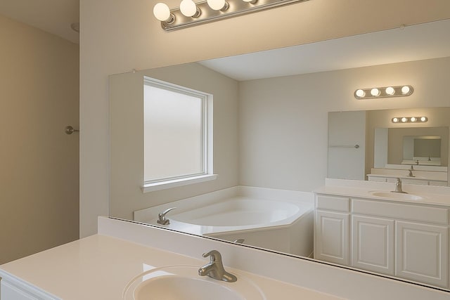 full bath featuring vanity and a garden tub