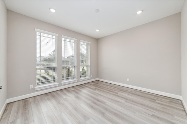 empty room with plenty of natural light and light hardwood / wood-style floors