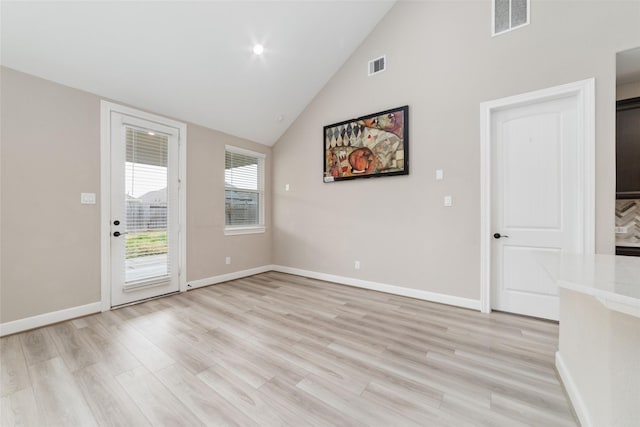 spare room featuring lofted ceiling and light wood-type flooring