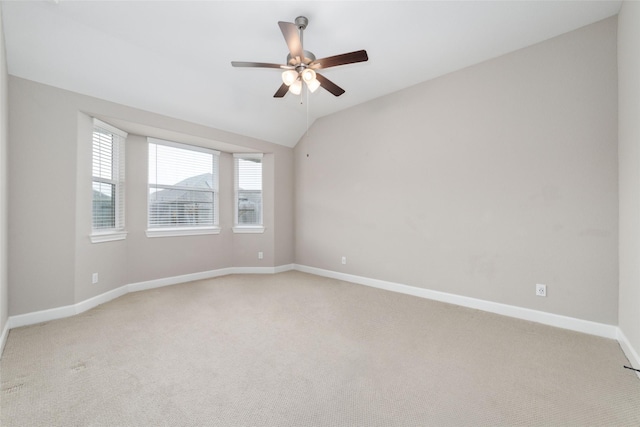 spare room featuring ceiling fan, vaulted ceiling, a healthy amount of sunlight, and carpet