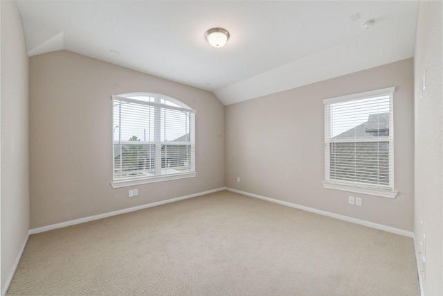 unfurnished room with light carpet and vaulted ceiling