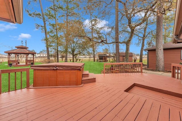 deck featuring a gazebo, a yard, and a hot tub