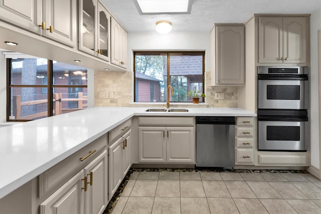 kitchen featuring white cabinets, appliances with stainless steel finishes, sink, and backsplash