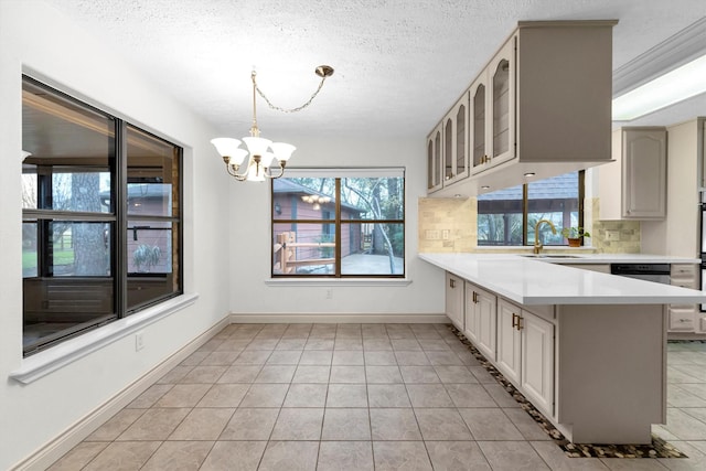 kitchen with tasteful backsplash, pendant lighting, kitchen peninsula, and a textured ceiling