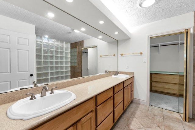 bathroom featuring vanity, tile patterned flooring, and a textured ceiling