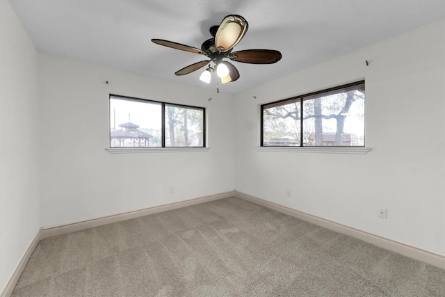 spare room featuring ceiling fan and light colored carpet