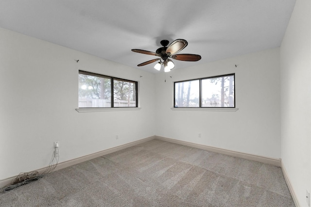 carpeted spare room with ceiling fan