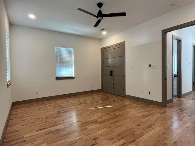 unfurnished bedroom featuring ceiling fan, multiple windows, and light wood-type flooring