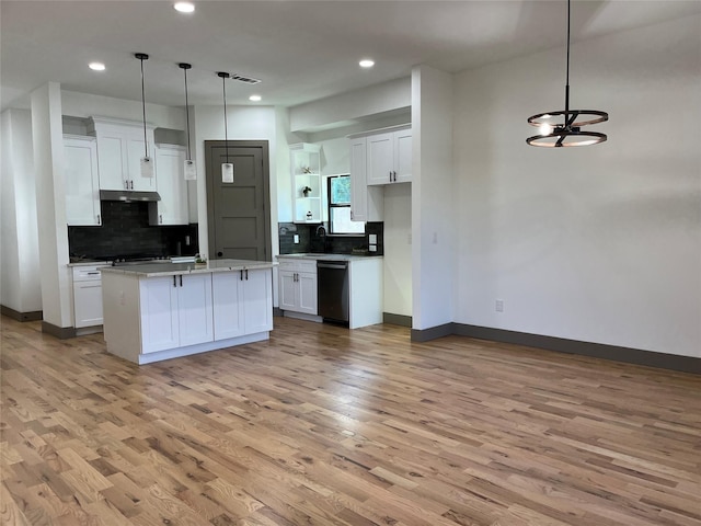 kitchen with decorative light fixtures, an island with sink, and white cabinets