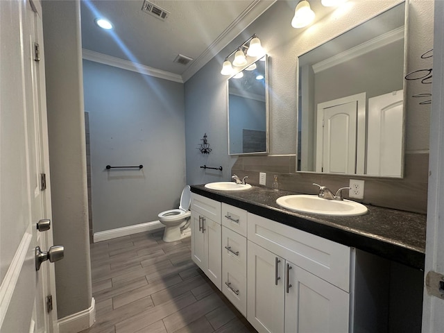 bathroom with tasteful backsplash, ornamental molding, vanity, and toilet