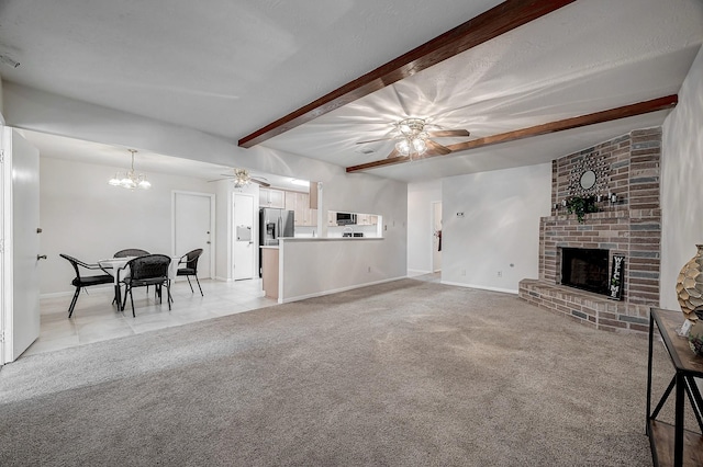 living room with beamed ceiling, a brick fireplace, ceiling fan with notable chandelier, and light colored carpet