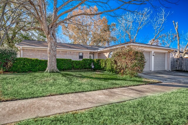 ranch-style house featuring a garage and a front lawn