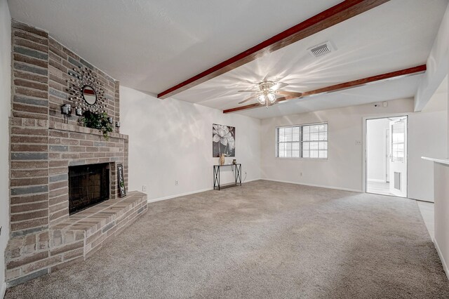 unfurnished living room with beamed ceiling, carpet floors, and a fireplace