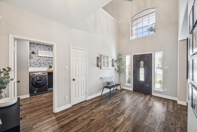 foyer featuring dark hardwood / wood-style floors, washer / clothes dryer, and a high ceiling