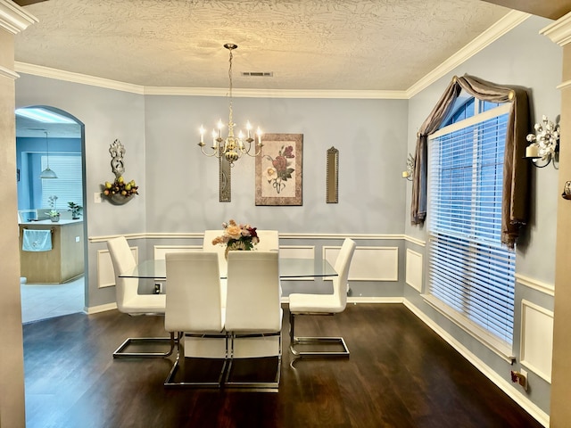 dining space with a notable chandelier, crown molding, dark hardwood / wood-style floors, and a textured ceiling