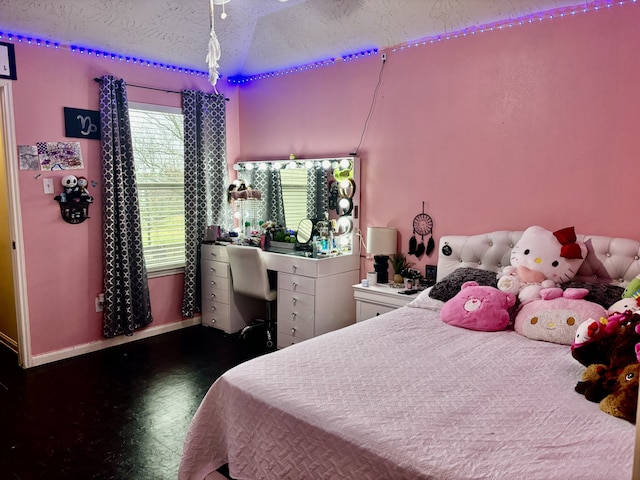 bedroom with lofted ceiling and a textured ceiling