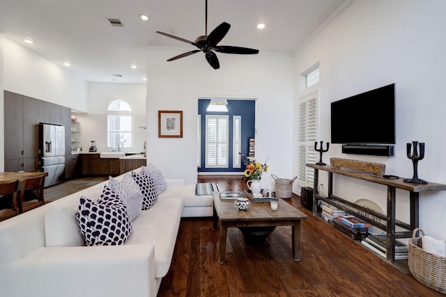 living room with hardwood / wood-style flooring, ornamental molding, and ceiling fan