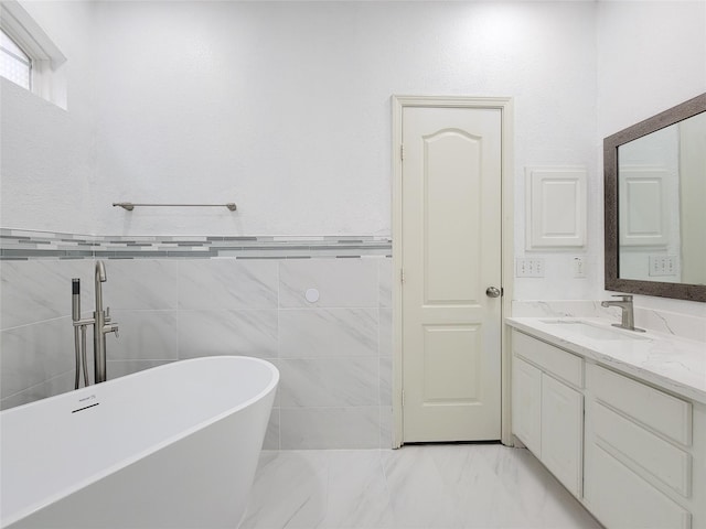 bathroom featuring a bathing tub, tile walls, and vanity