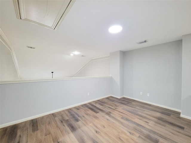 spare room with wood-type flooring and vaulted ceiling