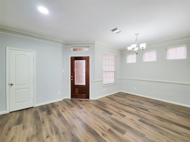 entryway featuring baseboards, wood finished floors, visible vents, and crown molding