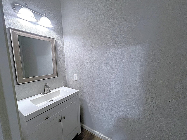 bathroom featuring a textured wall and vanity