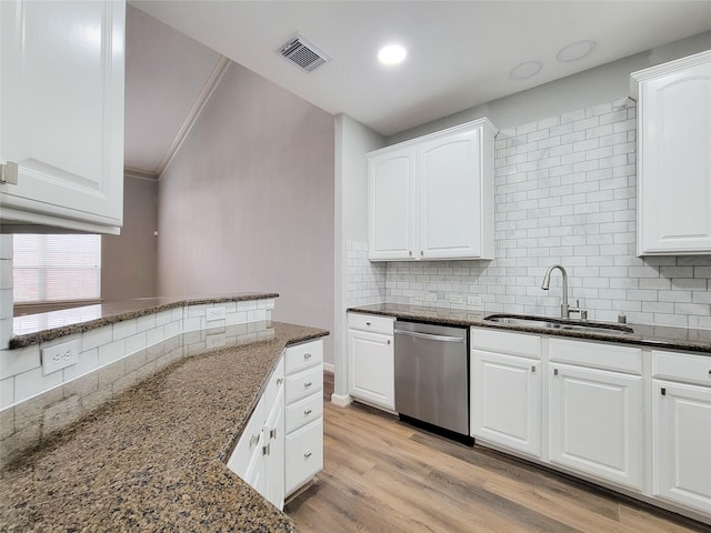 kitchen featuring dark stone counters, dishwasher, sink, and white cabinets