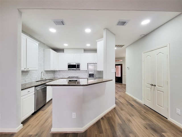 kitchen featuring white cabinetry, appliances with stainless steel finishes, sink, and hardwood / wood-style floors