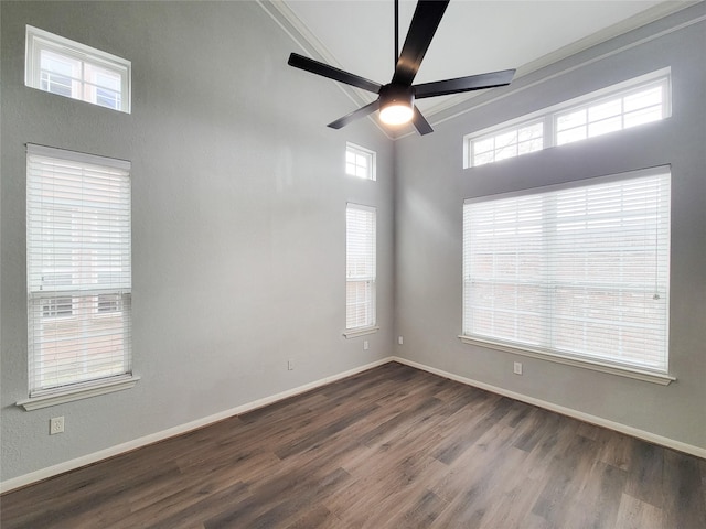 spare room featuring ceiling fan, baseboards, and dark wood finished floors