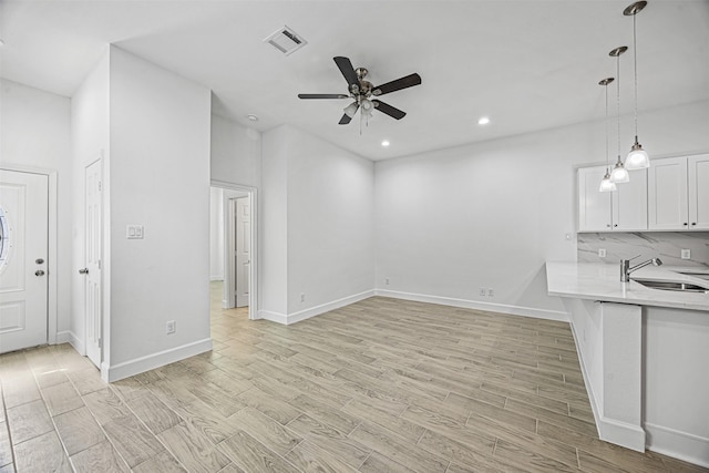 unfurnished living room with sink and ceiling fan