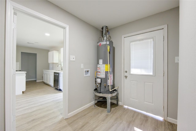 interior space with sink, water heater, and light wood-type flooring