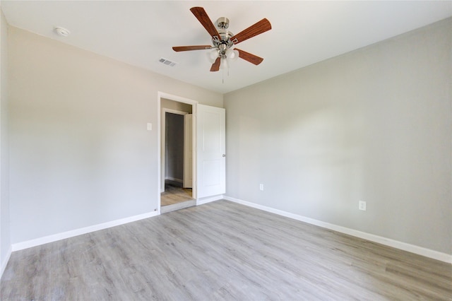 empty room with ceiling fan and light wood-type flooring