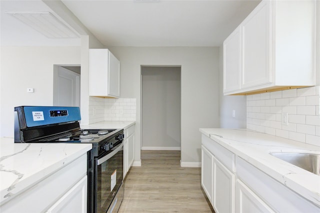 kitchen featuring white cabinetry, tasteful backsplash, light hardwood / wood-style flooring, stainless steel stove, and light stone countertops