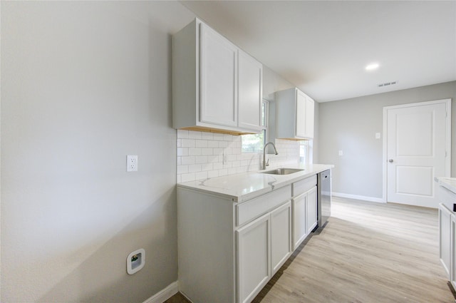 kitchen featuring white cabinetry, sink, tasteful backsplash, and light hardwood / wood-style flooring