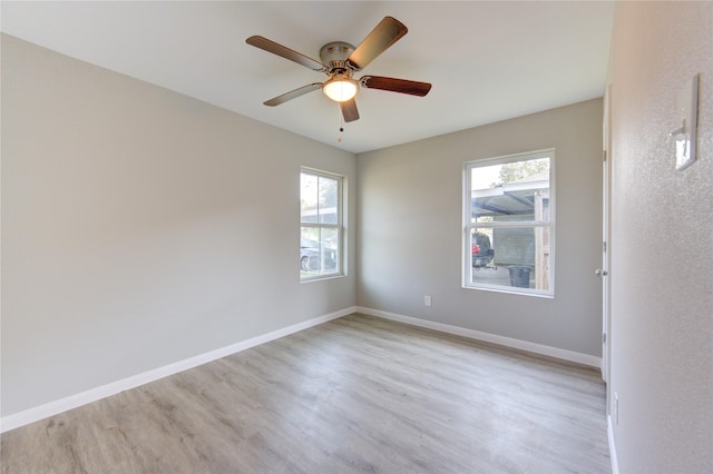 empty room featuring ceiling fan, plenty of natural light, and light hardwood / wood-style floors