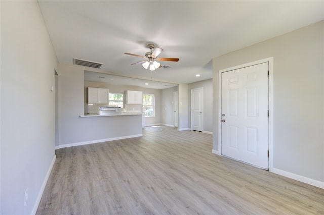 unfurnished living room with ceiling fan and light hardwood / wood-style floors