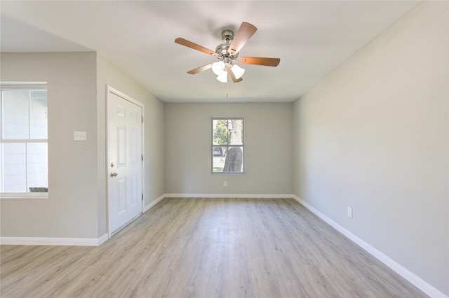 empty room with ceiling fan and light hardwood / wood-style flooring