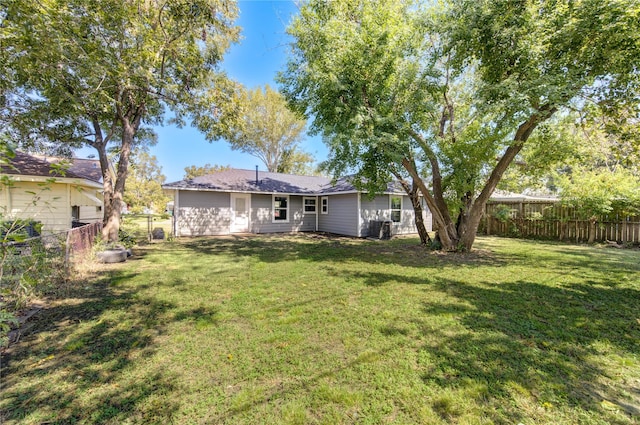 rear view of property with a yard and central AC