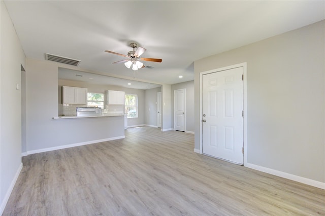 unfurnished living room featuring ceiling fan and light wood-type flooring