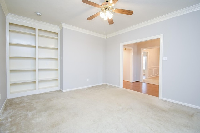 empty room with ceiling fan, light colored carpet, ornamental molding, and built in features