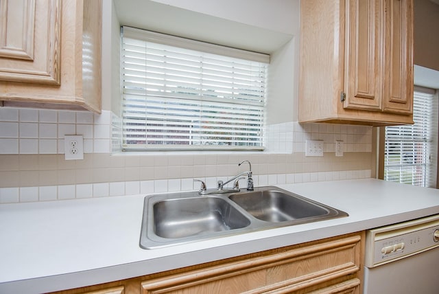 kitchen featuring tasteful backsplash, sink, light brown cabinets, and white dishwasher