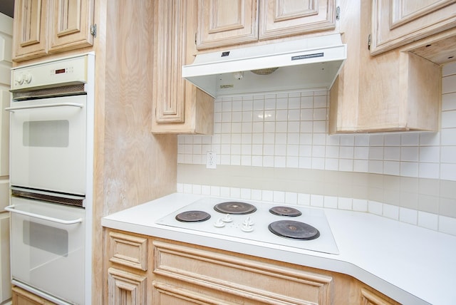 kitchen with light brown cabinets, white appliances, and decorative backsplash