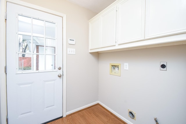 clothes washing area with cabinets, light hardwood / wood-style flooring, hookup for a washing machine, electric dryer hookup, and hookup for a gas dryer