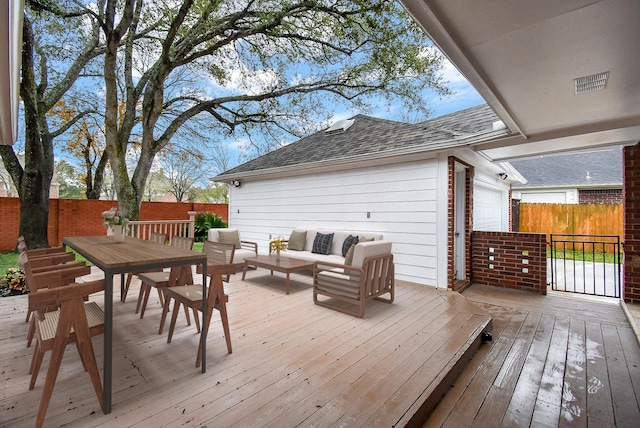 wooden terrace with a garage and outdoor lounge area