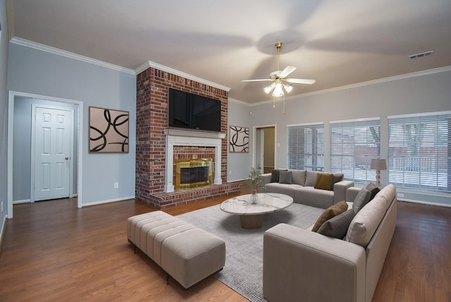 living room featuring hardwood / wood-style flooring, a fireplace, ornamental molding, and ceiling fan