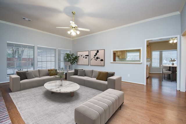 living room with ornamental molding, ceiling fan, and light hardwood / wood-style floors