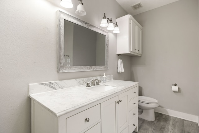 bathroom featuring vanity, hardwood / wood-style flooring, and toilet