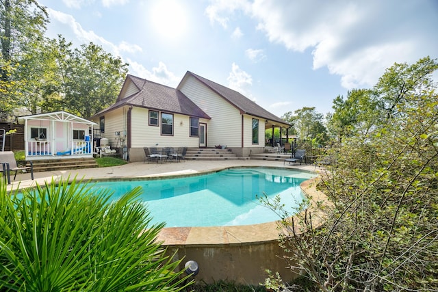 view of pool with a patio and an outbuilding