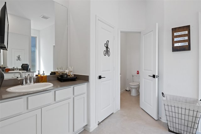 bathroom with vanity, toilet, and tile patterned flooring